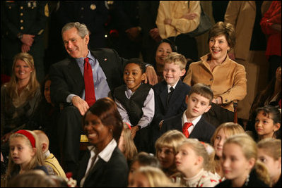 President George W. Bush and Mrs. Laura Bush sit with children of deployed U.S. military personnel and watch a performance of "Willy Wonka" by members of The Kennedy Center Education Department in the East Room Monday, Dec. 4, 2006. 
