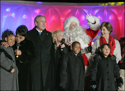 President George W. Bush and Laura Bush join entertainers Eartha Kitt, left, and Cathy Rigby, center, along with Santa Claus, invited children and The Singing Angels choir director Charles Eversole, right, on stage Thursday, Dec. 7, 2006, at the 2006 Christmas Pageant of Peace and the 83rd lighting of the National Christmas Tree on the Ellipse in Washington, D.C. 