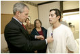President George W. Bush presents the Purple Heart to U.S. Army Staff Sgt. Robert Cordero of El Paso, during a visit Friday, Dec. 22, 2006, to the Walter Reed Army Medical Center where the soldier is recovering from injuries suffered in Operation Iraqi Freedom. Looking on with Mrs. Laura Bush is Sgt. Cordero's mother, Rosa.