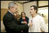 President George W. Bush presents the Purple Heart to U.S. Army Staff Sgt. Robert Cordero of El Paso, during a visit Friday, Dec. 22, 2006, to the Walter Reed Army Medical Center where the soldier is recovering from injuries suffered in Operation Iraqi Freedom. Looking on with Mrs. Laura Bush is Sgt. Cordero's mother, Rosa.