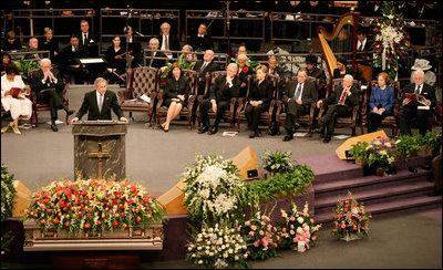 President George W. Bush addresses guests at the homegoing celebration for Coretta Scott King, Tuesday, Feb. 7, 2006 at the New Birth Missionary Church in Atlanta, Ga. In the background-right are Mrs. Laura Bush, former President Bill Clinton, U.S. Sen. Hillary Clinton, former President George H. W. Bush, former President Jimmy Carter, Mrs. Roslyn Carter and U.S. Sen. Edward M. Kennedy.