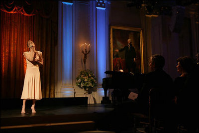 President George W. Bush and Laura Bush listen to country music artist LeAnn Rimes perform in the East Room of the White House during a dinner honoring The Dance Theatre of Harlem Monday, February 6, 2006.
