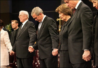 President George W. Bush and Mrs. Laura Bush are seen during a prayer holding hands with former President Bill Clinton, right, and Rev. Robert Schuller, left, at the homegoing celebration for Coretta Scott King, Tuesday, Feb. 7, 2006 at the New Birth Missionary Church in Atlanta, Ga.