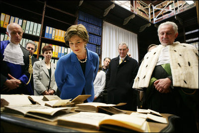 Laura Bush looks at books dating to the 1500’s during a tour of the Ancient Library at the University of Turin guided by Paolo Novaria, Archives, left, and Enrico Artifoni, right, Saturday, Feb. 11, 2006, in Turin, Italy.