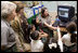 Laura Bush and Fran Mainella look on as students of Stella Summer’s Gifted Science class work with Ranger Maria Beotegui Thursday, Feb. 16, 2006, to navigate through Web Rangers, the online version of Junior Rangers, during a visit to Banyan Elementary School in Miami, FL. The National Junior Ranger Programs promote knowledge of science, history, the environment and learning through fun.