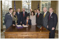 Accompanied by Laura Bush and legislators, President George W. Bush signs H.R. 3402, The Violence Against Women and Department of Justice Reauthorization Act of 2005, during a ceremony in the Oval Office Thursday, Jan. 5, 2005. The bill is a comprehensive package that reauthorizes Department of Justice programs to combat domestic violence, dating violence, sexual assault, and stalking.