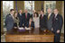Accompanied by Laura Bush and legislators, President George W. Bush signs H.R. 3402, The Violence Against Women and Department of Justice Reauthorization Act of 2005, during a ceremony in the Oval Office Thursday, Jan. 5, 2005. The bill is a comprehensive package that reauthorizes Department of Justice programs to combat domestic violence, dating violence, sexual assault, and stalking.