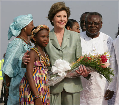 Mrs. Laura Bush stands with 10-year-old Aisha Garuba Sunday, Jan. 15, 2006, after she presented Mrs. Bush with flowers upon her arrival at Kotoka International Airport in Accra, Ghana.