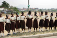 Students at Model Secondary School in Abuja, Nigeria, wave American flags as they line the street during a visit by Laura Bush Wednesday, Jan. 18, 2006.