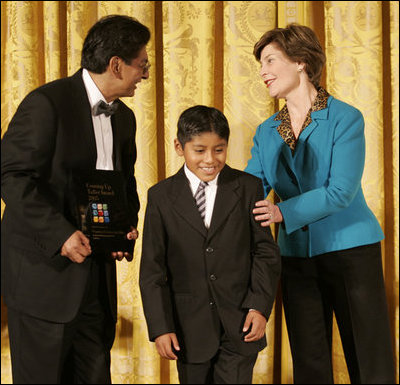 Laura Bush congratulates Jose Fernando Salas, left, and Carlos Gabriel Pascual from the Art and Children Program of Veracruz, Mexico, at their award presentation Wednesday, Jan. 25, 2006 in the East Room of the White House, during the President's Committee on the Arts and the Humanities 2006 Coming Up Taller Awards ceremony.