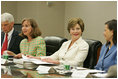 Mrs. Laura Bush smiles at Dina Hibab Powell, Deputy Under Secretary for Public Diplomacy, Public Affairs and Assistant Secretary of State for Educational and Cultural Affairs during the fifth meeting of the U.S. Afghan Women's Council at the State Department, Wednesday, July 5, 2006, in Washington, D.C. Also shown are Dr. Paula Dobrianksy, Under Secretary of State for Democracy and Global Affairs, left, and James Kunder, Assistant Administrator for Asia and the Near East, USAID.