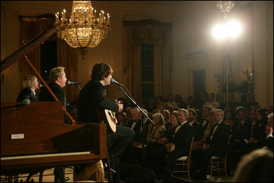 President George W. Bush, Mrs. Laura Bush and guests listen to the band Rascal Flatts in the East Room of the White House following a dinner honoring the Special Olympics and founder Eunice Kennedy Shriver, Monday, July 10, 2006.