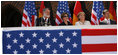 Mrs. Laura Bush is seated between Stralsund Mayor Harald Lastovka and German Chancellor Angela Merkel during the welcoming ceremony Thursday, July 13, 2006, in honor of the visit by President George W. Bush and Laura Bush to Stralsund, Germany.