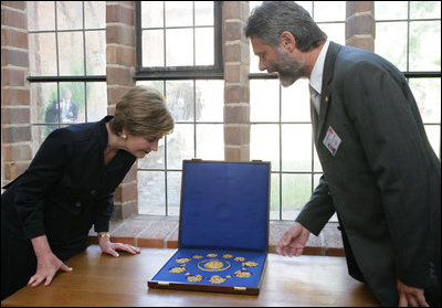 Mrs. Laura Bush is shown jewelry artifacts on her tour of the City of Stralsund Archives in Stralsund, Germany, Thursday, July 13, 2006, by Dr. Andreas Gruger, director of the Stralsund Museum of Cultural History.