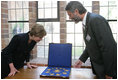 Mrs. Laura Bush is shown jewelry artifacts on her tour of the City of Stralsund Archives in Stralsund, Germany, Thursday, July 13, 2006, by Dr. Andreas Gruger, director of the Stralsund Museum of Cultural History.