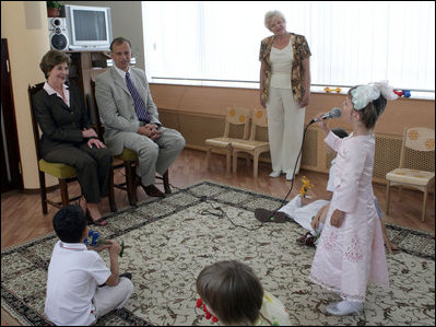 During a tour of the Pediatric HIV/AIDS Clinic Center of Russia, Mrs. Laura Bush and Dr. Evgeny Voronin listen to Gayla, a patient, perform in the Music Room Friday, July 14, 2006, in St. Petersburg, Russia. Music instructor Valentina Leontieva looks on.
