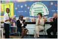 Mrs. Laura Bush joins Our Lady of Perpetual Help School principal Charlene Hursey, left, and Cardinal Theodore McCarrick, Archbishop of Washington, D.C., in applauding student Marquette Lewis, 11, after his reading of the poem "Coming of Age," Monday, June 5, 2006. Mrs. Bush visited the school to announce a Laura Bush Foundation for America's Libraries grant to Our Lady of Perpetual Help School.