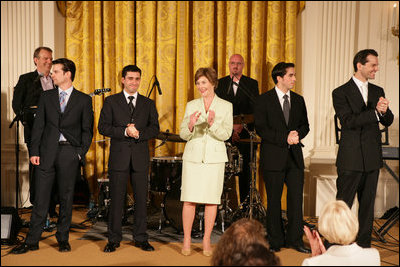 Mrs. Laura Bush stands with members of the cast from the Tony award-winning musical Jersey Boys perform during a luncheon for Senate Spouses in the East Room Monday, June 12, 2006.