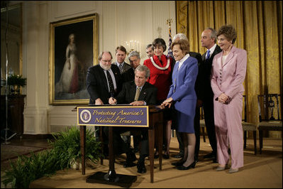 President George W. Bush signs a proclamation to create the Northwestern Hawaiian Islands Marine National Monument at a ceremony Wednesday, June 15, 2006, in the East Room of the White House. The proclamation will bring nearly 140,000 square miles of the Northwestern Hawaiian Island Coral Reef Ecosystem under the nation's highest form of marine environmental protection. Mrs. Laura Bush joined the President and distinguished guests on stage, from left to right, U.S. Rep. Neil Abercrombie, D-Hawaii; U.S. Rep. Ed Case, D-Hawaii; U.S. Sen. Daniel Akaka, D-Hawaii; U.S. Commerce Secretary Carlos Gutierrez; Hawaii Gov. Linda Lingle; documentary filmmaker Jean-Michel Cousteau; marine biologist Sylvia Earle and U.S. Interior Secretary Dirk Kempthorne.