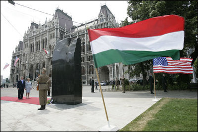 President George W. Bush and Mrs. Laura Bush stand in silence after laying flowers at the eternal flame of the 1956 Memorial Monument outside the Hungarian Parliament in Budapest, Hungary, Thursday, June 22, 2006. The monument honors victims of the 1956 Hungarian uprising against Soviet rule.