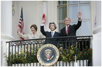 President George W. Bush, Laura Bush and Prime Minister Junichiro Koizumi of Japan wave from the Truman Balcony at the conclusion of the official arrival ceremony Thursday, June 29, 2006.