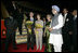 President George W. Bush and Mrs. Bush stand with flowers presented upon their arrival Wednesday, March 1, 2006, at New Delhi's Indira Gandhi International Airport where they were greeted by India's Prime Minister Manmohan Singh, right, and his wife, Gursharan Kaur.