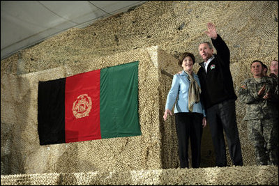 President George W. Bush and Laura Bush wave to an audience of U.S. and Coalition troops, Wednesday, March 1, 2006, upon their arrival to Bagram Air Base in Afghanistan.