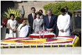 President George W. Bush and Laura Bush are joined by Rajnish Kumar, right, Secretary of the Rajghat Samadhi Committee, and Dr. Nirmila Deshpande, co-Chair of the Rajghat Gandhi Samadhi committee, for a moment of silence at the Mahatma Gandhi Memorial in Rajghat, India on March 2, 2006.