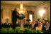 President George W. Bush joins in the celebration of International Women's Day at the White House Tuesday, March 7, 2006, as he thanks the female members of his audience for their leadership. "The struggle for women's right is a story of strong women willing to take the lead," the President told them and added, America's "a better place because of the leadership of women throughout our history."