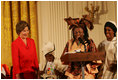 Mrs. Laura Bush reacts to remarks from Aunt Manyongo "Kunene" Mosima Tantoh, a member of the Mothers to Mothers-To-Be organization of South Africa, Monday, March 13, 2006 in the East Room at the White House. Mrs. Bush had earlier met with members of the group, who mentor and counsel mothers who come for prenatal care to clinics and find they are HIV-positive, on her visit to South Africa in July of 2005. Group member Gloria Ncanywa is seen at right.