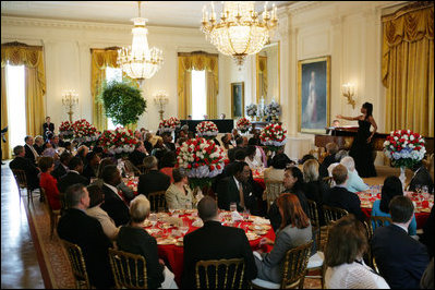 President George W. Bush and Mrs. Laura Bush join invited guests in listening to vocal star Denyce Graves at a White House social luncheon in honor of Liberia's President Ellen Johnson Sirleaf, Tuesday, March 21, 2006, at the White House.