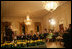 President George W. Bush and Mrs. Laura Bush join their invited guests in listening to Benjamin Franklin interpreter, Ralph Archbold of Philadelphia, Pa., Thursday evening, March 23, 2006 in the East Room of the White House, during a Social Dinner to honor the 300th birthday of Benjamin Franklin.