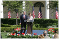 Mrs. Laura Bush and President George W. Bush address guests in the Rose Garden during an event honoring the recipients of the Preserve America Presidential Awards May 1, 2006.
