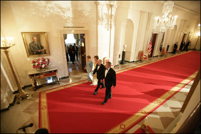 President George W. Bush and Laura Bush walk with Australian Prime Minister John Howard and his wife Mrs. Janette Howard through the Cross Hall as they arrive for the official dinner held in honor of the Prime Minister Tuesday, May 16, 2006.