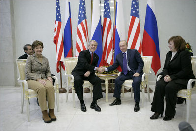 President George W. Bush and Russia's President Vladimir Putin exchange handshakes Wednesday, Nov. 15, 2006, as Mrs. Laura Bush and Lyudmila Putina look on. The brief Moscow stop was the first on the President and First Lady's week-long trip.