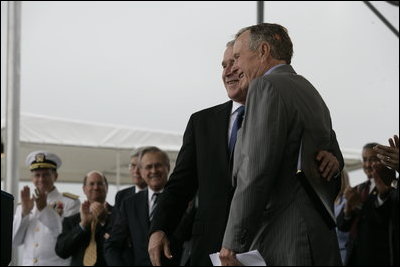 President George W. Bush hugs his father, Former President George H. W. Bush, after delivering remarks at the Christening Ceremony for the George H.W. Bush (CVN 77) in Newport News, Virginia, Saturday, Oct. 7, 2006.