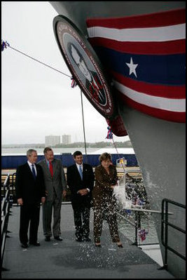 President George W. Bush joins his father, Former President George H. W. Bush and Northrop Grumman President Mike Petters, as his sister Doro Bush Koch breaks the bottle to christen the George H.W. Bush (CVN 77) in Newport News, Virginia, Saturday, Oct. 7, 2006.