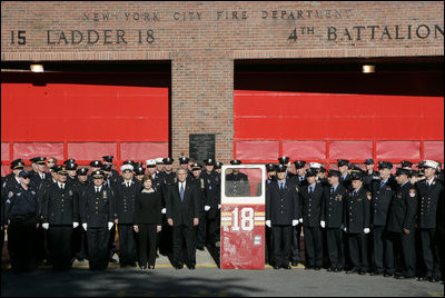 President George W. Bush and Laura Bush stand with New York City First Responders at the Fort Pitt Firehouse for a moment of silence Monday, September 11, 2006, in New York City to commemorate the fifth anniversary of the September 11th terrorist attacks. Also pictured is a door from Ladder 18, which was destroyed in the collapse of the World Trade Center.