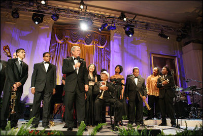 President George W. Bush stands with performers on stage in the East Room Thursday night, Sept. 14, 2006, as he offers closing remarks to guests at the Thelonious Monk Institute of Jazz dinner at the White House.