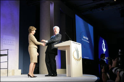 Mrs. Laura Bush is welcomed to the podium by former President Bill Clinton Wednesday, September 20, 2006, at President Clinton's Annual Global Initiative Conference in New York. During her remarks, Mrs. Bush announced a $60 million public-private partnership between the U.S. Government and the Case Foundation to provide clean water for up to 10 million people in sub-Sahara Africa by 2010. The partnership will support the provision and installation of PlayPump water systems in approximately 650 schools, health centers and HIV affected communities.