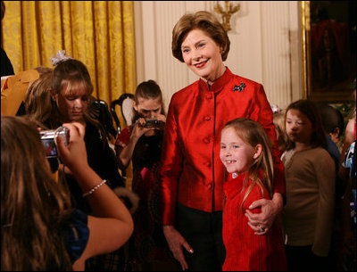 Mrs. Laura Bush poses for a photo with a young guest following the performance of the Ford Theater cast members presentation of "A Christmas Carol," Monday, Dec. 3, 2007, at the White House Children's Holiday Reception. 
