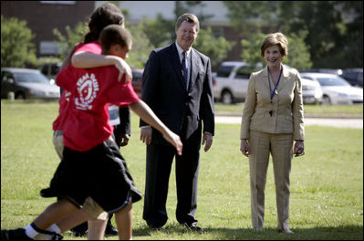 Mrs. Laura Bush and Mike Gottfried, CEO of Team Focus, watch Team Focus participants run a relay race Thursday, June 21, 2007, in Mobile, Ala., during a visit to Team Focus's National Leadership Camp, as part of Helping America's Youth initiative. Team Focus is a faith-based, nonprofit organization devoted to improving the lives of young men, ages 10-18, without fathers in their lives.