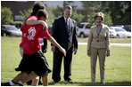 Mrs. Laura Bush and Mike Gottfried, CEO of Team Focus, watch Team Focus participants run a relay race Thursday, June 21, 2007, in Mobile, Ala., during a visit to Team Focus's National Leadership Camp, as part of Helping America's Youth initiative. Team Focus is a faith-based, nonprofit organization devoted to improving the lives of young men, ages 10-18, without fathers in their lives.