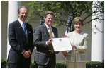 Mrs. Laura Bush presents a plaque to John McLaughlin, center, president and CEO of the USS Midway Museum in San Diego, Calif., and Scott McGaugh, marketing director of the museum, honoring them with a 2007 Preserve America Presidential Award in the Rose Garden at the White House Wednesday, May 9, 2007.