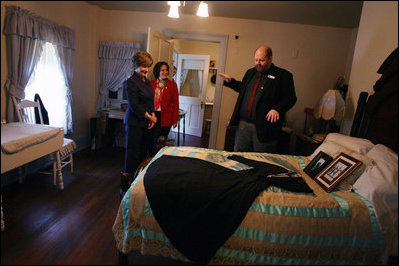 Mrs. Laura Bush, joined by her Chief of Staff Anita McBride, listens to Russell Caldwell, manager of visitor services, as he describes artifacts during a tour of the Margaret Mitchell House and Museum, Thursday, Nov. 1, 2007 in Atlanta, Ga. It was in this house that Mitchell wrote the novel, Gone with the Wind.
