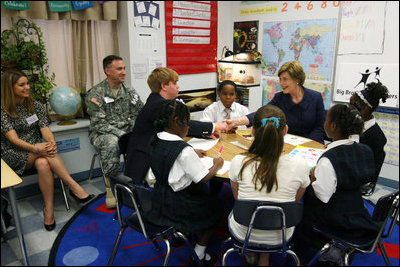 Mrs. Laura Bush shakes hands with student Taylor McIntyre, during her visit with students at the Good Shepherd Nativity Mission School, Thursday, Nov. 1, 2007 in New Orleans, a Helping America's Youth visit with Big Brother and Big Sisters of Southeast Louisiana. Captain Richard T. Douget, second from left, is a Big Brother to Taylor McIntyre.