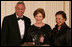 Mrs. Laura Bush is joined on stage by former Secretary of State Colin Powell and his wife, Alma Powell, as they present Mrs. Bush with a National Promise of America Founders Award, Tuesday evening, Nov. 13, 2007, during a social dinner to celebrate the tenth anniversary of America's Promise-The Alliance for Youth.