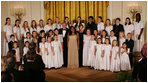 President George W. Bush and Mrs. Laura Bush join singer Melinda Doolittle, center, and members of the World Children's Choir on stage Tuesday evening, Nov. 13, 2007in the East Room of the White House, during the social dinner in honor of the tenth anniversary of America's Promise-The Alliance for Youth.