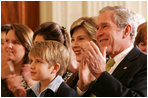 President George W. Bush and Mrs. Laura Bush are joined by Elijah Atkins, Friday, Nov. 16, 2007 in the East Room of the White House, as they listen to Atkins' father, country music star Rodney Atkins, performing for guests during the celebration of National Adoption Day. Rodney Atkins is the 2007-2008 national celebrity spokesperson for The National Council for Adoption.