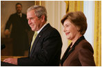 President George W. Bush is joined by Mrs. Laura Bush in the East Room of the White House, Friday, Nov. 16, 2007, in an address to invited guests in celebration of National Adoption Day. President Bush, in speaking to parents and children, said he was "So thankful that the parents and children here today have found the gift of one another. And I encourage our citizens across the land to explore adoption, look into the joys of adoption, and provide love for somebody who needs it."